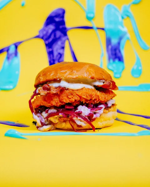 Burger su sfondo giallo con schizzi di vernice